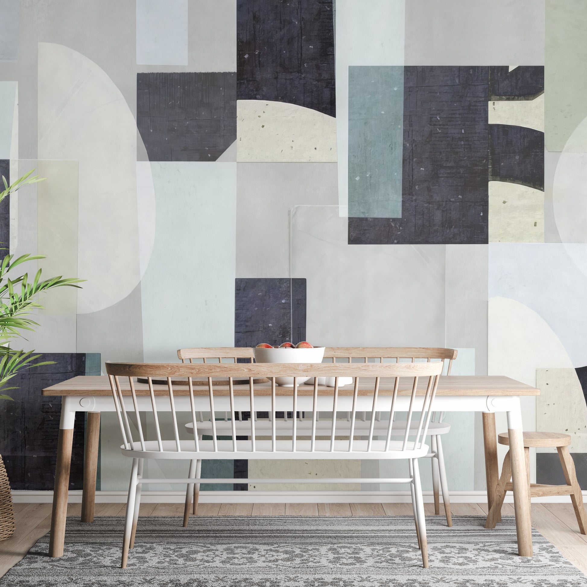 Abstract Geometric wallpaper mural in navy, sage and cream shapes behind a wood dining table and white bench
