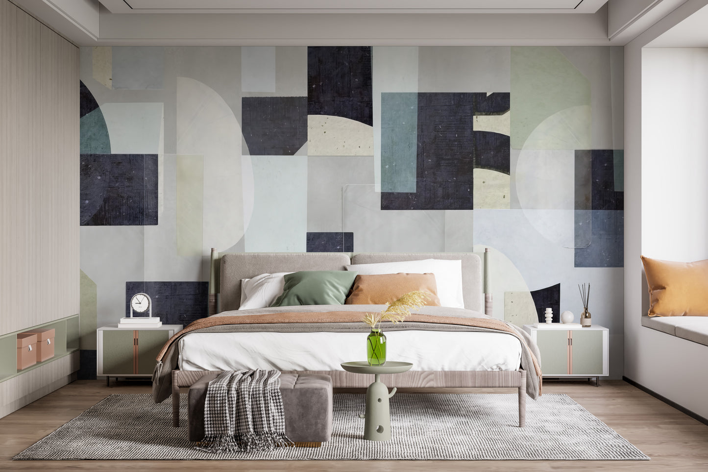 Abstract Geometric wallpaper mural with navy and cream shapes behind a beige bed with green pillows in a bedroom