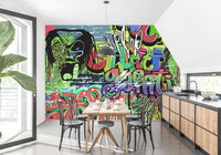 Vibrant Graffiti wallpaper mural in a kitchen diner with a wooden table, black bistro chairs and wood cabinets