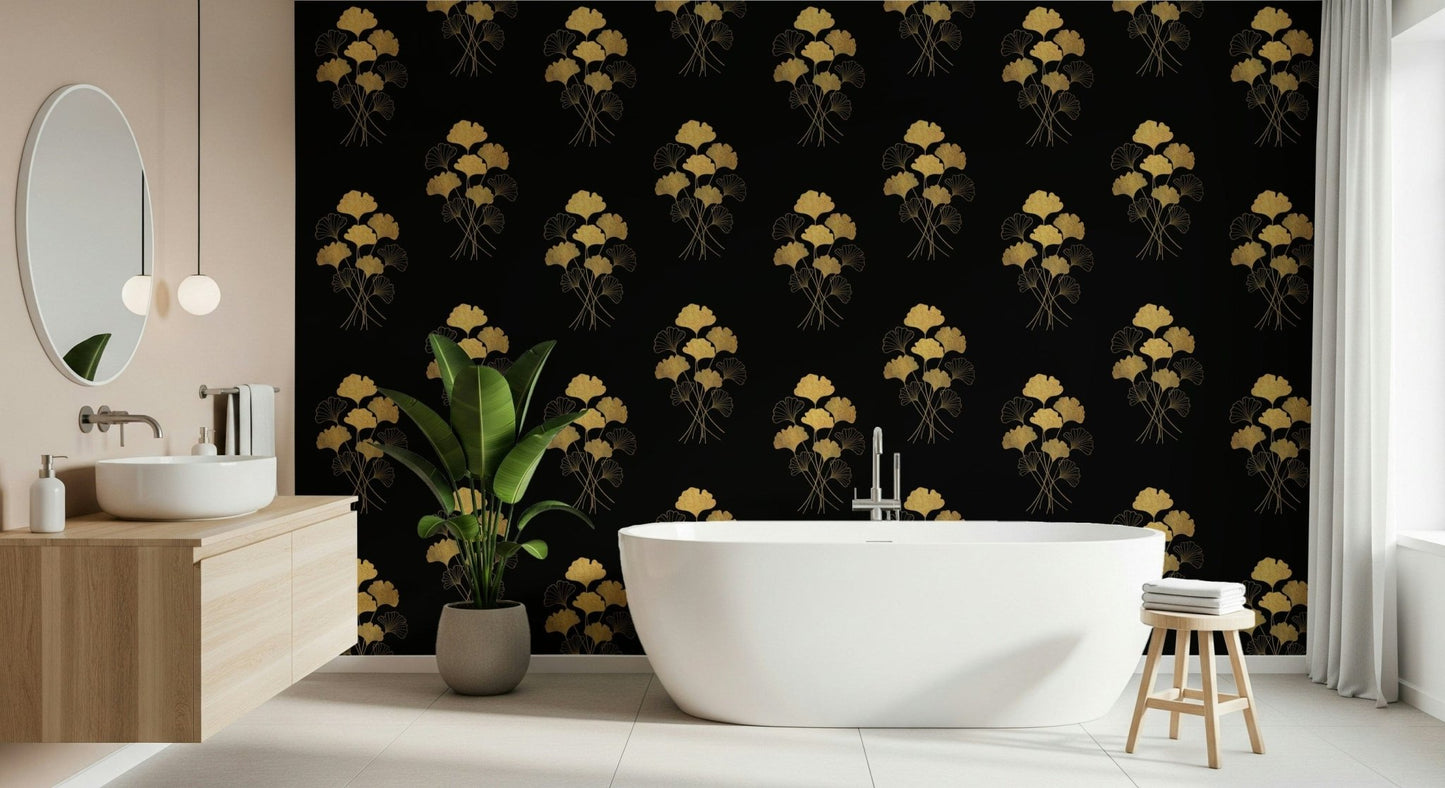 Ginkgo Luxury Gold wallpaper mural of gold ginkgo leaves on black beside a freestanding white tub and wood vanity in a bathroom