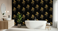 Ginkgo Luxury Gold wallpaper mural of gold ginkgo leaves on black beside a freestanding white tub and wood vanity in a bathroom