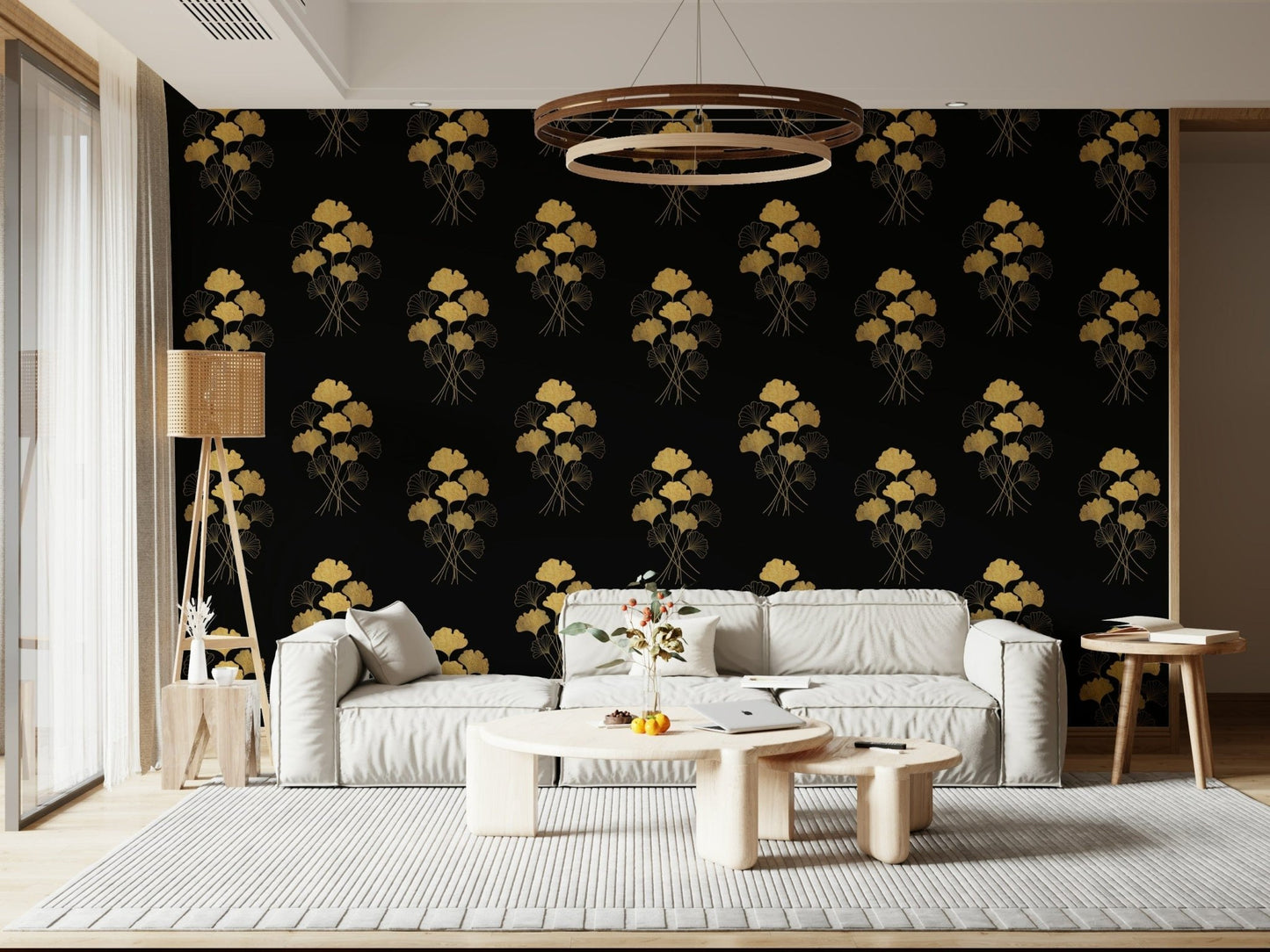 Ginkgo Luxury Gold wallpaper mural of gold ginkgo motifs on black behind a white sofa under a ring chandelier in a living room