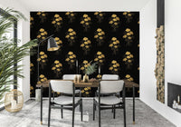 Ginkgo Luxury Gold wallpaper mural with gold ginkgo leaves on black behind a wood dining table and black-framed chairs