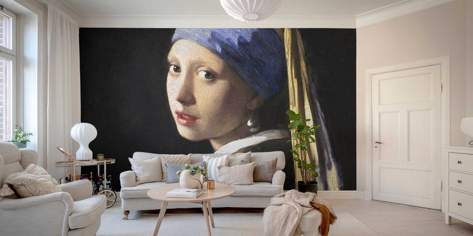 Girl Pearl Earring wallpaper mural styled along a hallway feature wall near a console in a multicolour palette