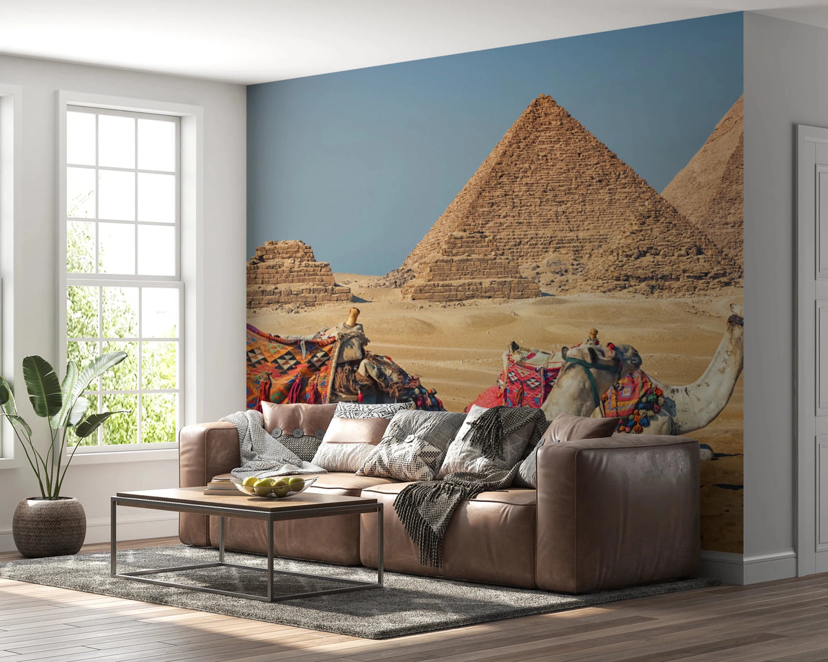 Giza wall mural of the pyramids and resting camels behind a brown leather sectional sofa in a bright living room