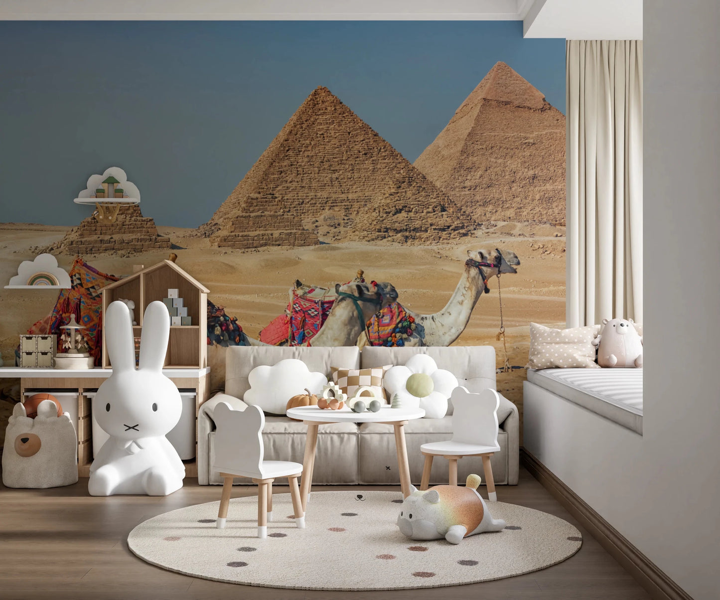 Giza wall mural of the pyramids and camels in a playroom with a white sofa, toddler table and bunny lamp