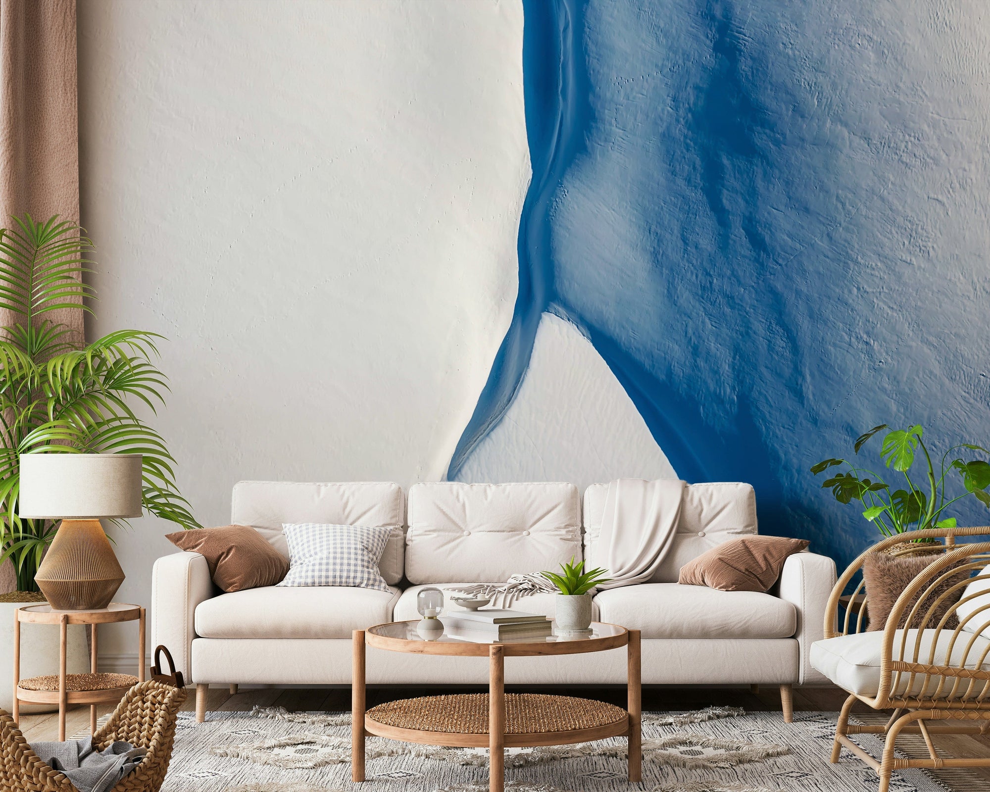 Glacial Edge wallpaper mural in cool blue and white behind a cream sofa and rattan armchair in a bright living room