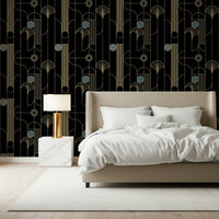 Golden Arcadia Harmony Deco wallpaper in black and gold deco shapes behind a beige upholstered bed with gold lamp