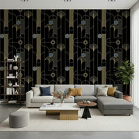 Golden Arcadia Harmony Deco wallpaper in black and gold deco shapes behind a grey sectional with mustard pillows
