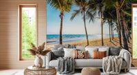 Golden Beach Palms wallpaper mural of a sunny beach behind a grey sofa with boho pillows