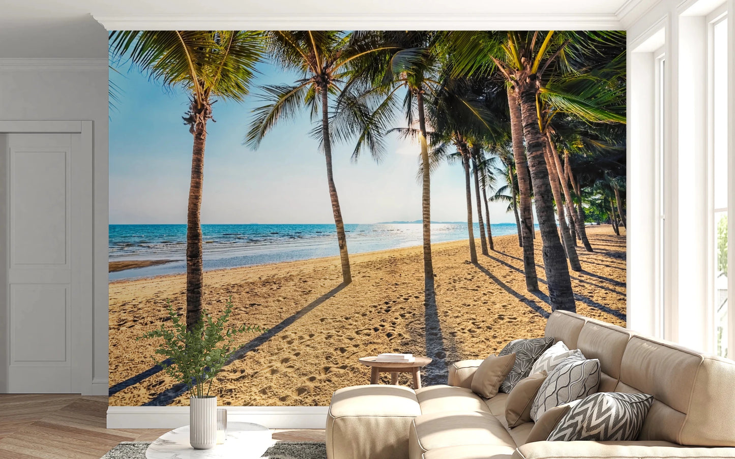 Golden Beach Palms wallpaper mural with palm shadows on sand behind a beige sectional sofa in a living room