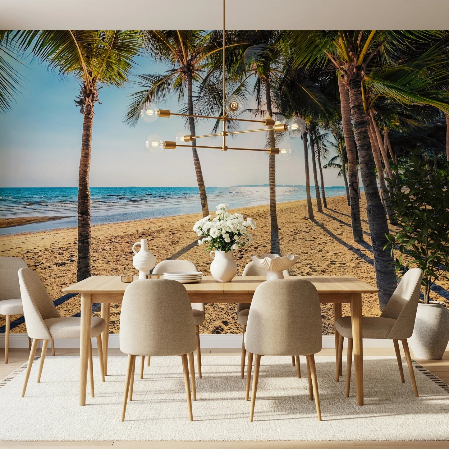 Golden Beach Palms wallpaper mural of palm trees on sand behind a wood dining table and beige chairs