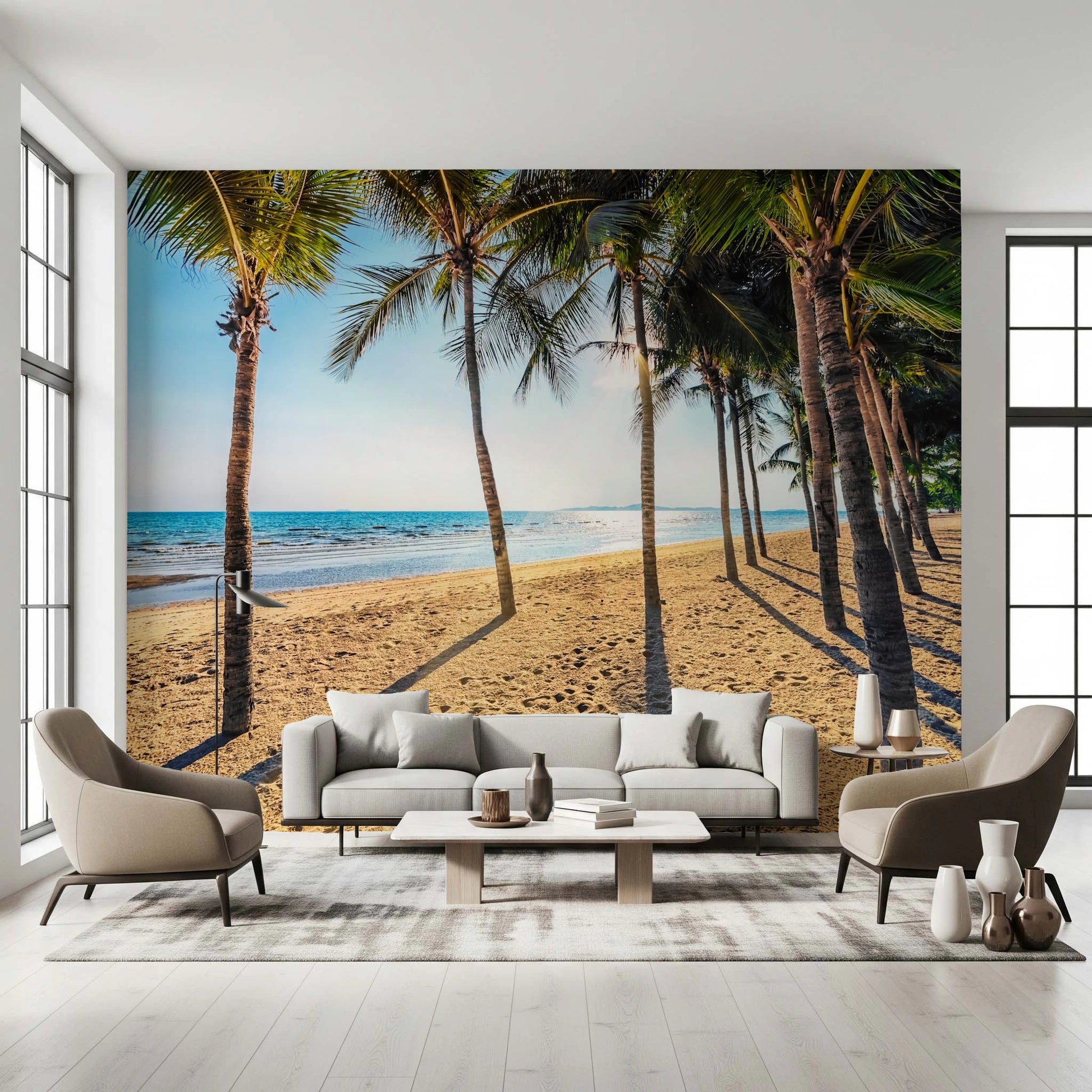 Golden Beach Palms wallpaper mural with palm trees and sea behind a white sofa and two taupe armchairs