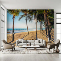 Golden Beach Palms wallpaper mural with palm trees and sea behind a white sofa and two taupe armchairs