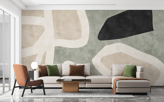 Golden Geometric Abstract wallpaper mural in beige and sage with black shapes behind a cream sectional sofa
