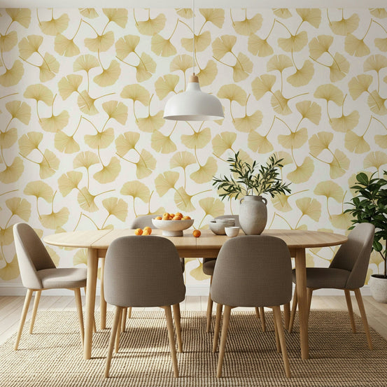 Golden Ginkgo Breeze wallpaper with yellow ginkgo leaves behind a wood dining table and taupe chairs