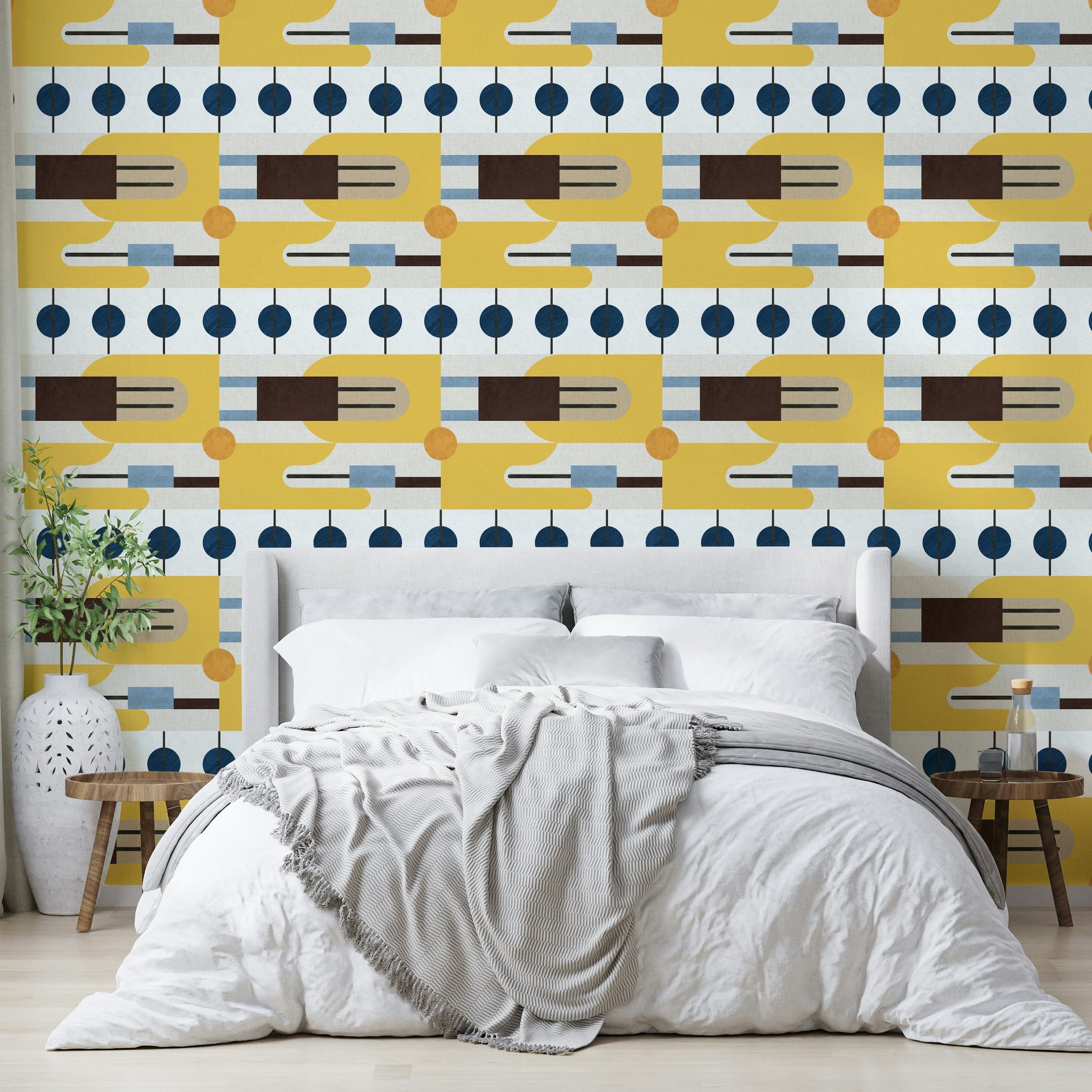 Golden Hour Hues wallpaper behind a grey upholstered bed with white bedding and an olive branch vase