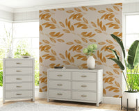 A warm neutral wallpaper decorated with delicate golden branches and softly shaded leaves.