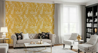 Golden Meadow Dream wallpaper in yellow and white florals behind a cream tufted sofa and black bookcase