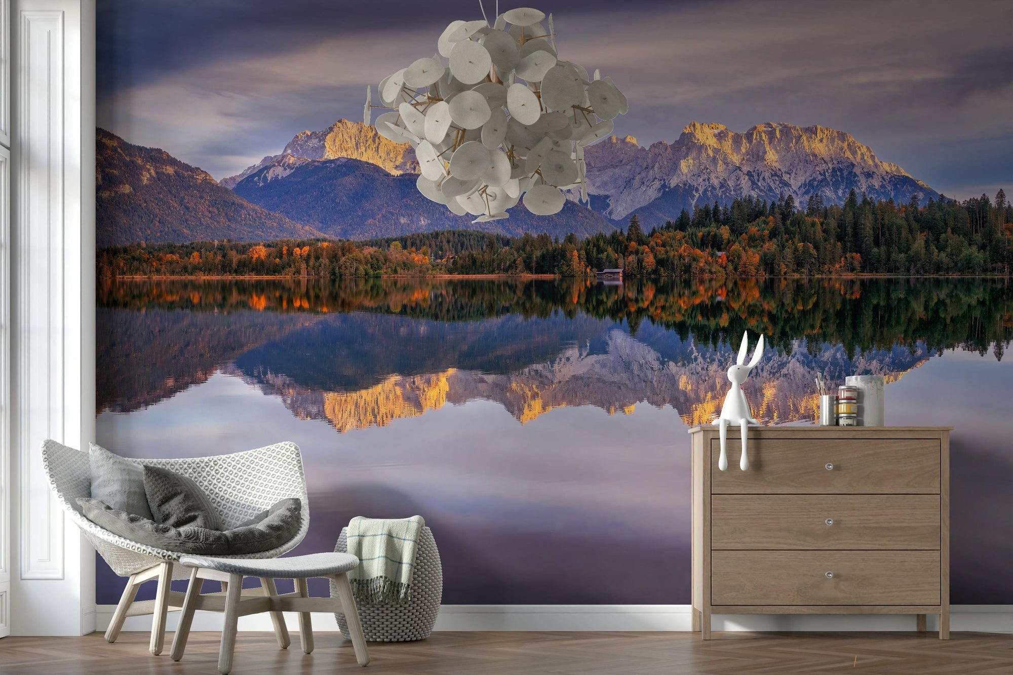 Golden Peaks Reflection wallpaper mural of sunlit alps mirrored in a lake behind a white chair and wood dresser