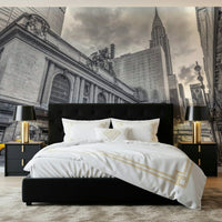 Grand Central Terminal mural in black and white with yellow taxis behind a black bed with white and gold bedding