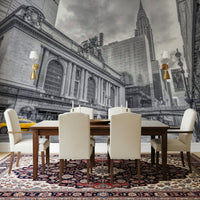 Grand Central Terminal mural over a wood dining table and cream chairs on a red Persian rug