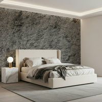 Granite Gray wallpaper mural above a cream upholstered bed with a marble cube nightstand and grey throw