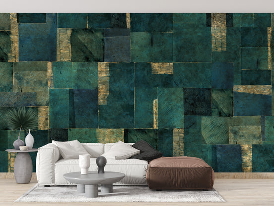 Green Abstract wallpaper mural in teal and gold patchwork behind a white sofa and brown ottoman in a living room