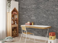 Grey brick mural behind a wooden study table setup