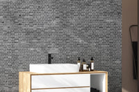 Grey brick wallpaper mural in a modern  bathroom with natural light.
