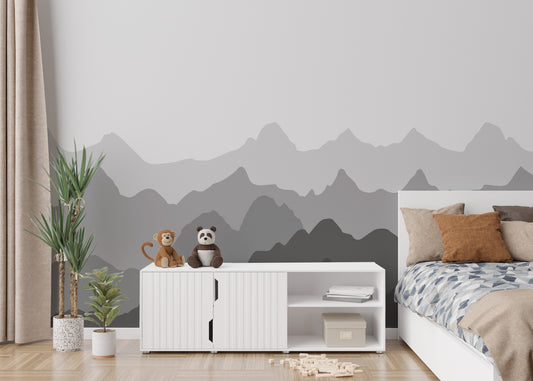 Grey Silhouettes Mountains wallpaper mural above a white bed and toy sideboard in a kids bedroom