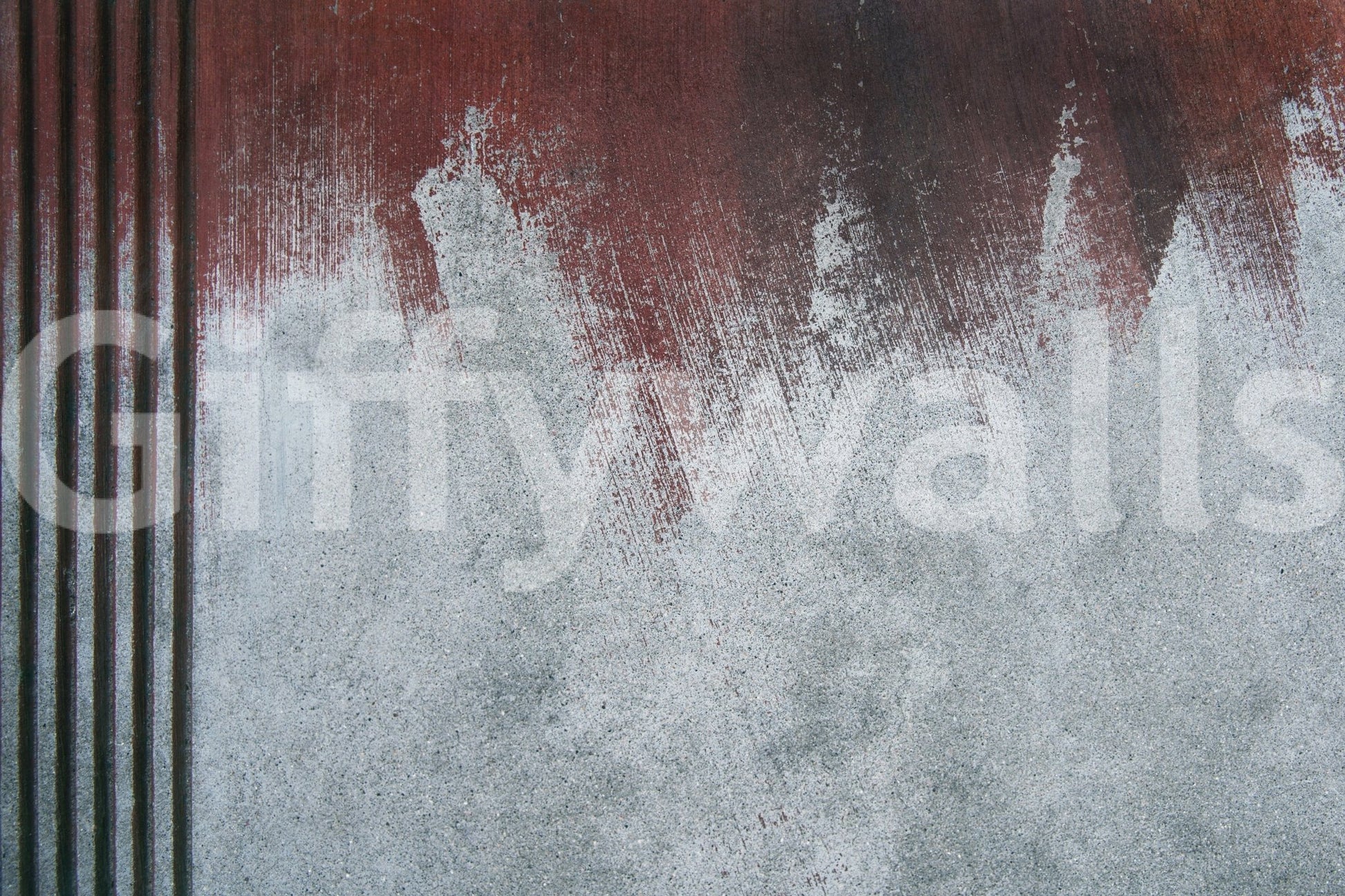 Gritty Fade wallpaper mural close-up showing a rust-red wash fading into pale grey weathered concrete