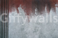 Gritty Fade wallpaper mural close-up showing a rust-red wash fading into pale grey weathered concrete