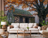 Rustic cottage wall mural for living room with autumn leaves and mossy stone cabin