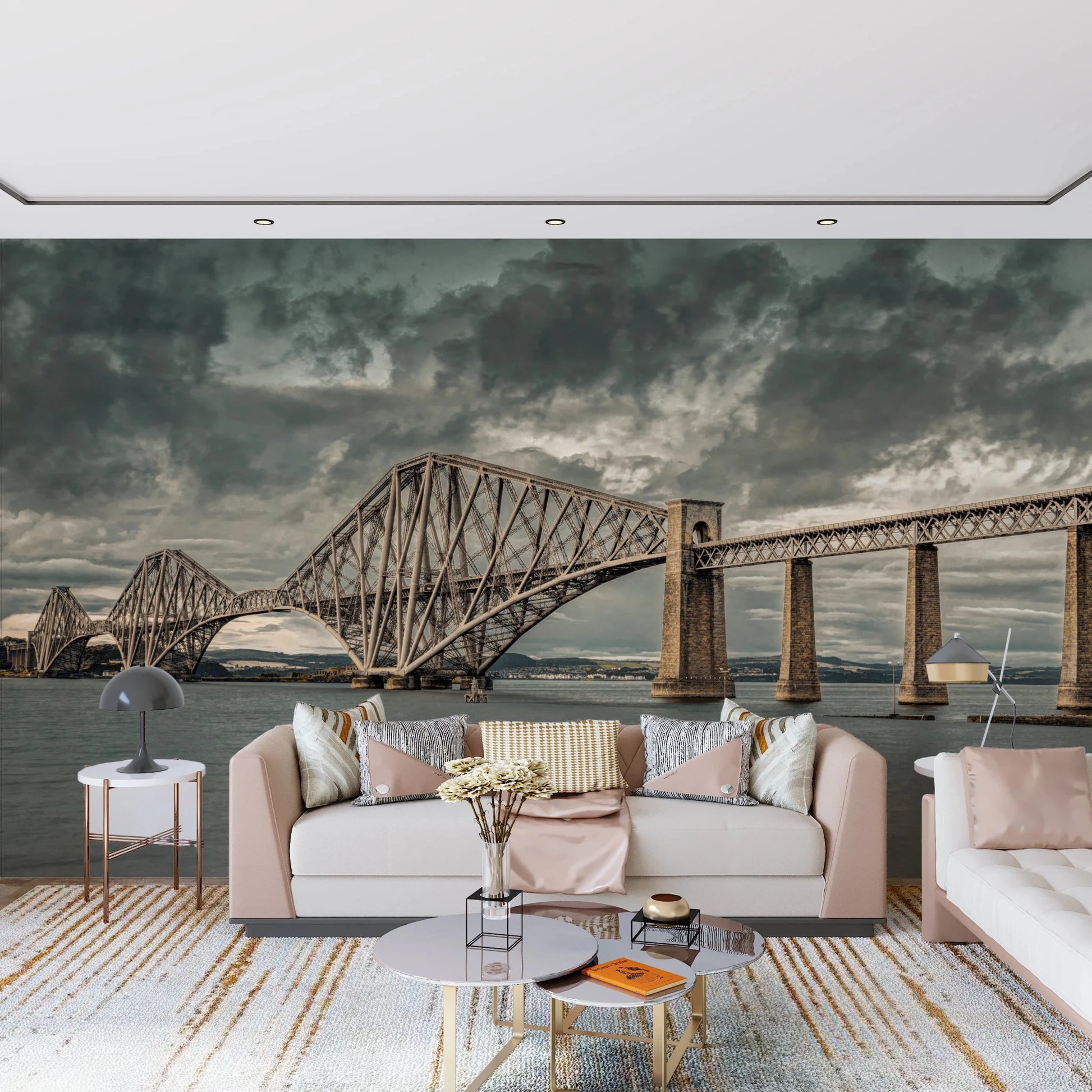 Historic Forth Rail Bridge wall mural with dramatic clouds behind a pale pink living room sofa