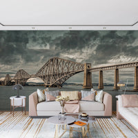 Historic Forth Rail Bridge wall mural with dramatic clouds behind a pale pink living room sofa
