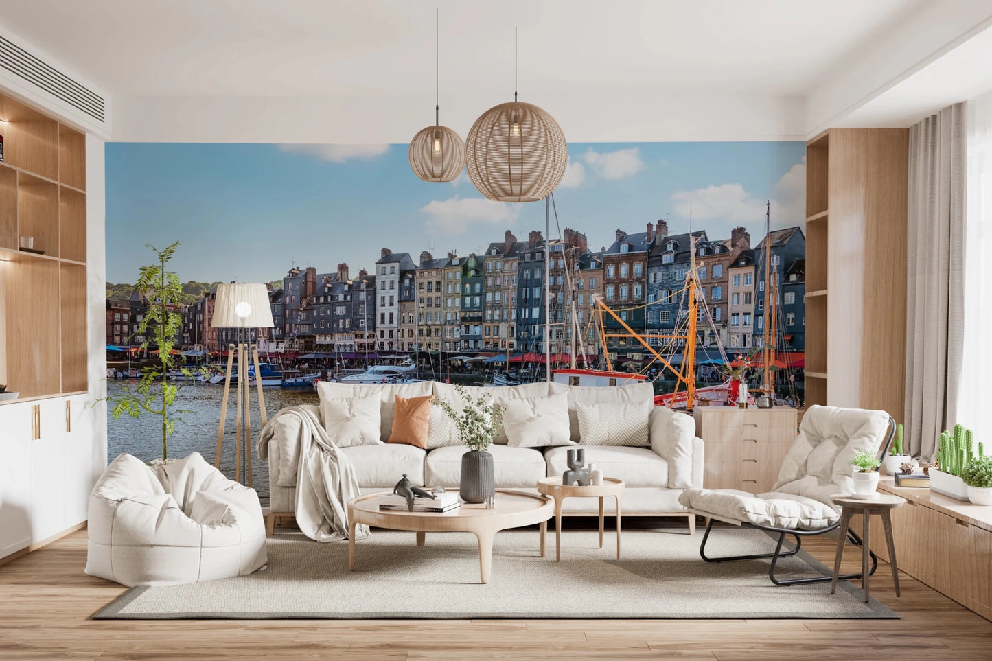 Honfleur Harbor Charm wallpaper mural of the harbor and houses behind a white sofa with woven globe pendants