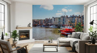 Honfleur Harbor Charm wallpaper mural of the harbor and red boat behind a white sectional beside a fireplace