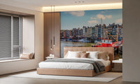 Honfleur Harbor Charm wallpaper mural of the sunny harbor and red boat behind a tan leather bed in a bedroom