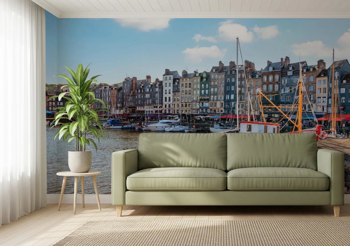 Honfleur Harbor Charm wallpaper mural of the harbor townhouses and sailboats behind a sage green sofa