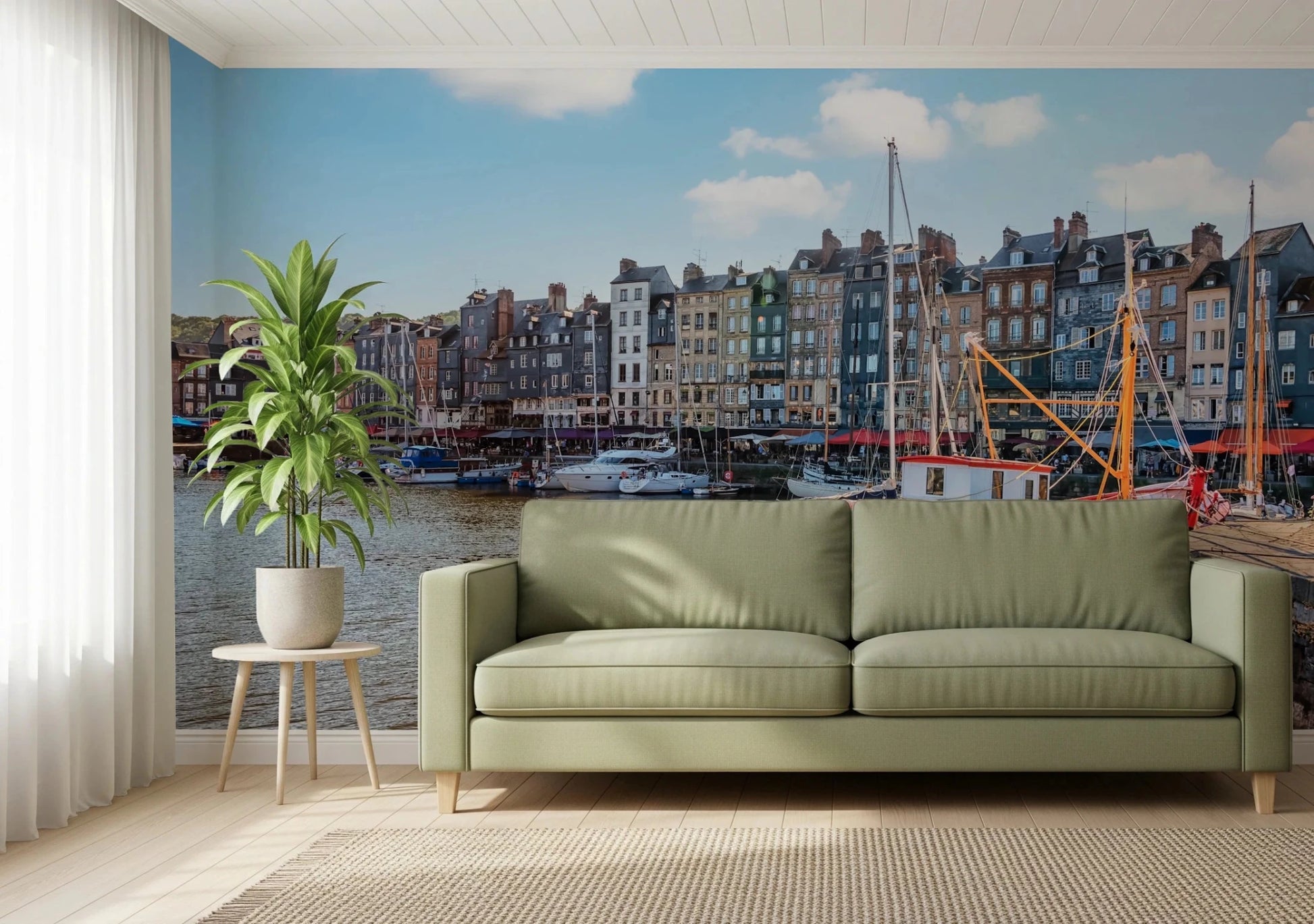 Honfleur Harbor Charm wallpaper mural of the harbor townhouses and sailboats behind a sage green sofa