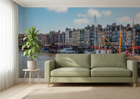 Honfleur Harbor Charm wallpaper mural of the harbor townhouses and sailboats behind a sage green sofa