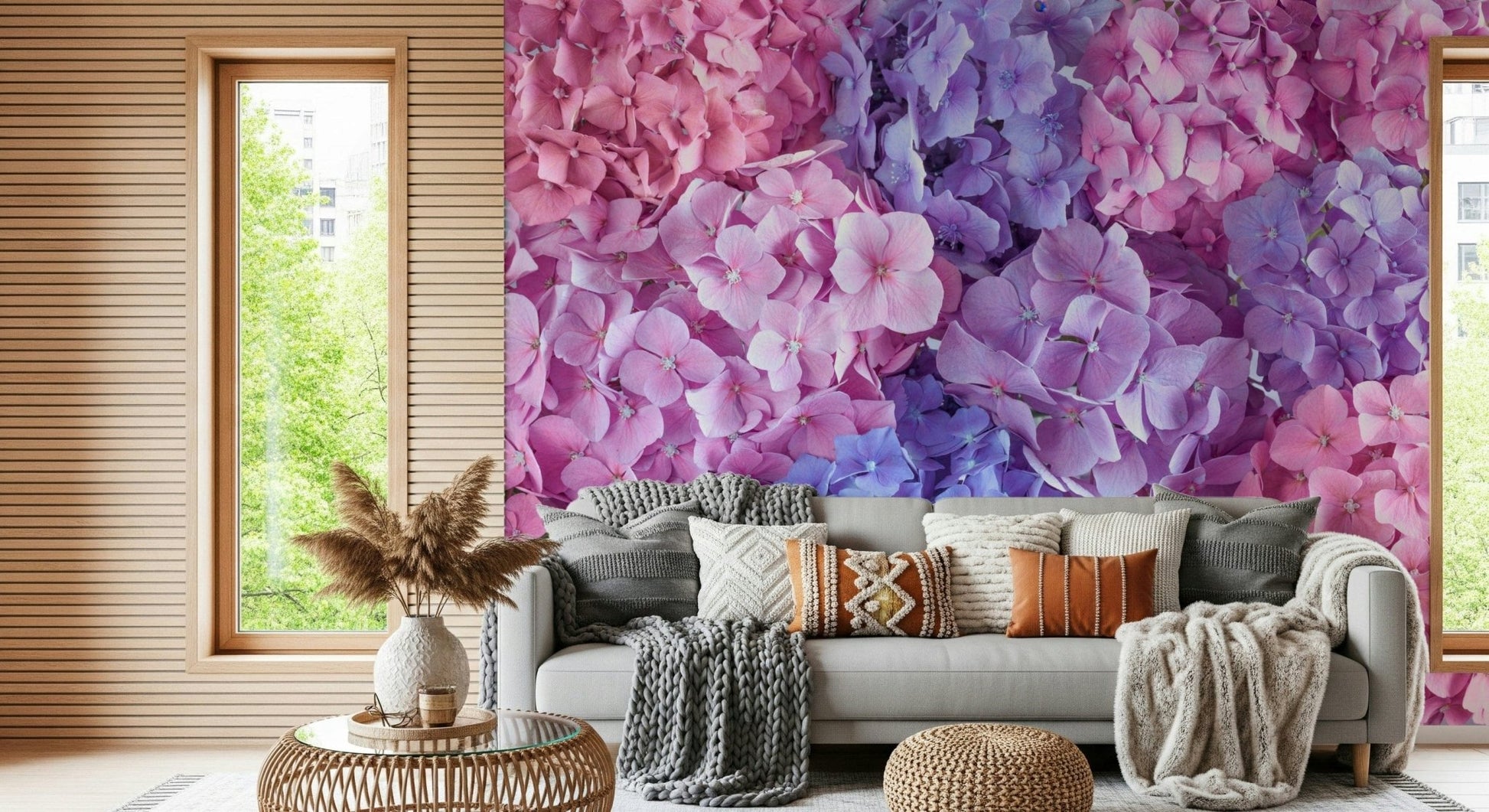 Hydrangea Hues wallpaper mural of vivid hydrangea blooms behind a grey sofa with knit throws in a living room