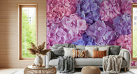 Hydrangea Hues wallpaper mural of vivid hydrangea blooms behind a grey sofa with knit throws in a living room