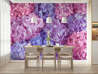 Hydrangea Hues wallpaper mural of pink and purple blooms in a dining room with a wood table and white pendant lamps
