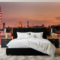 Iconic London at Dusk wall mural of Big Ben and the London Eye behind a black tufted bed with gold lamps in a bedroom