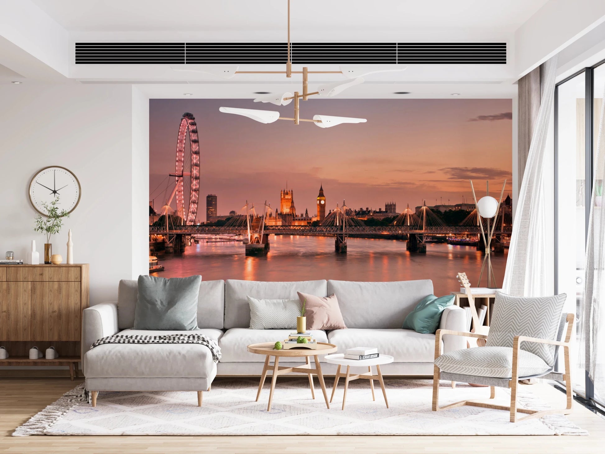 Iconic London at Dusk wall mural of the Thames skyline behind a grey sectional under a gold chandelier in a living room