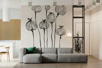 Ink Poppy Pods wallpaper mural of black sketched seed pods behind a gray low sofa with a green cushion