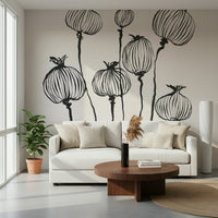 Ink Poppy Pods wallpaper mural with sketched poppy pods behind a white sofa and walnut round coffee table