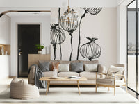 Ink Poppy Pods wallpaper mural with black seed pods behind a beige sofa and wood coffee table in a living room